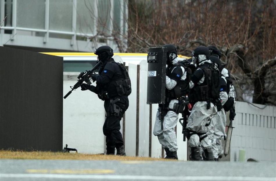 Armed offender squad members prepare to enter a Cromwell house suspected of being a...