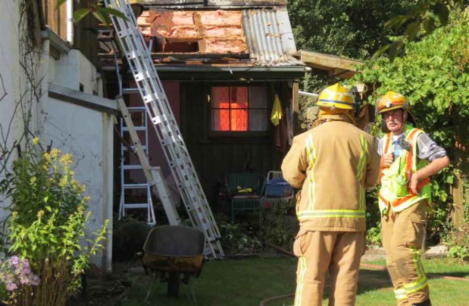 Arrowtown and Frankton firefighters on Easter Monday assess the damage resulting from  a fire in...