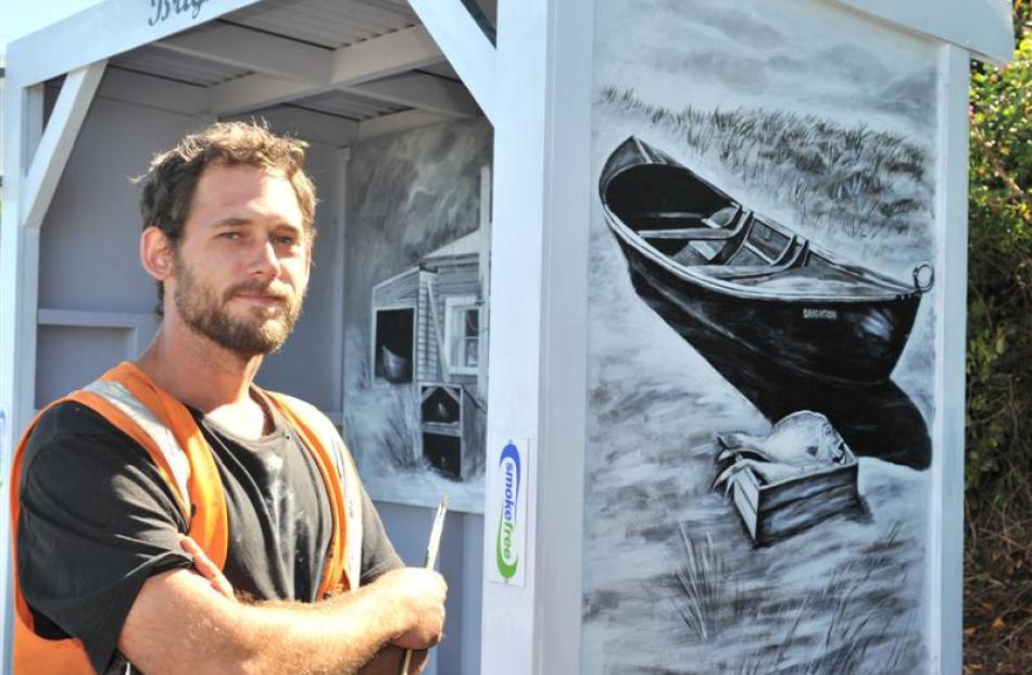 Artist Daniel Mead was  brightening up  a bus shelter on Brighton Rd on Friday. Photo by Linda...