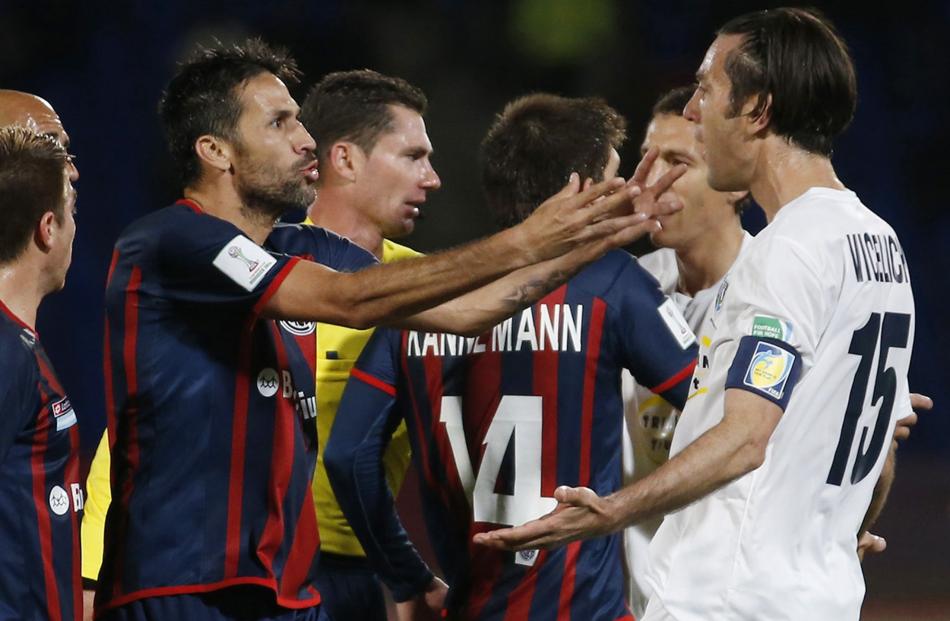 Auckland City's Ivan Vicelich (R) argues with San Lorenzo's Mario Yepes after the referee showed...