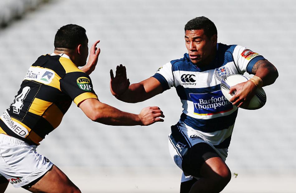 Auckland winger Charles Piutau looks to fend off an oncoming Taranaki defender. Photo by Getty...