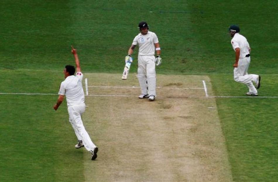Australia's Mitchell Starc celebrates taking his first test wicket, that of New Zealand’s Brendon...