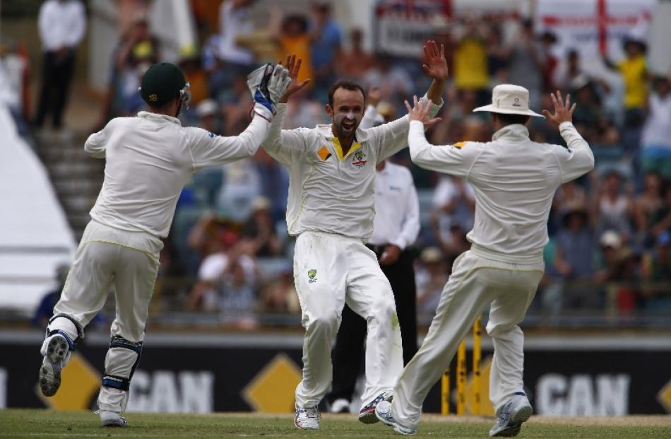 Australia's Nathan Lyon (centre) celebrates with captain Michael Clarke (right) and Brad Haddin...