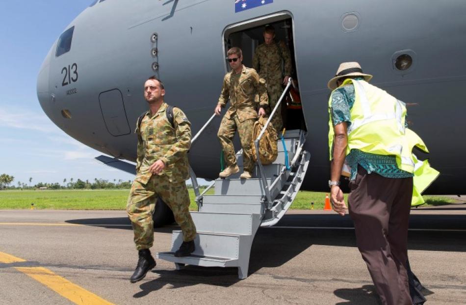 Australian Army troops disembark from a Royal Australian Air Force C-17A aircraft after landing...