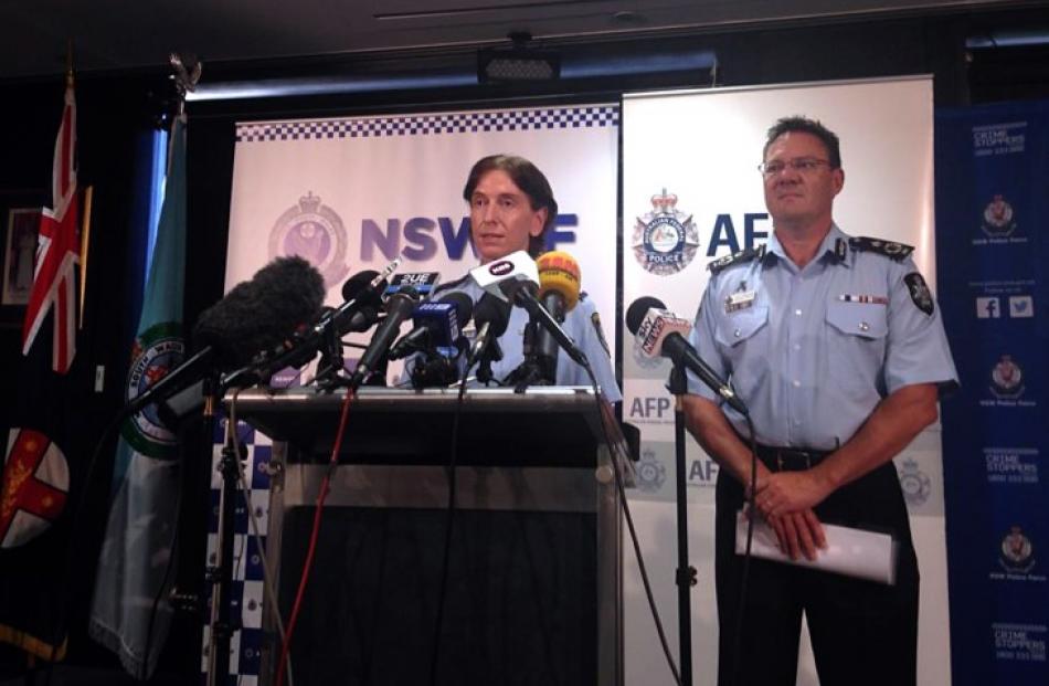 Australian Federal Police Deputy Commissioner Michael Phelan (R) listens as New South Wales...