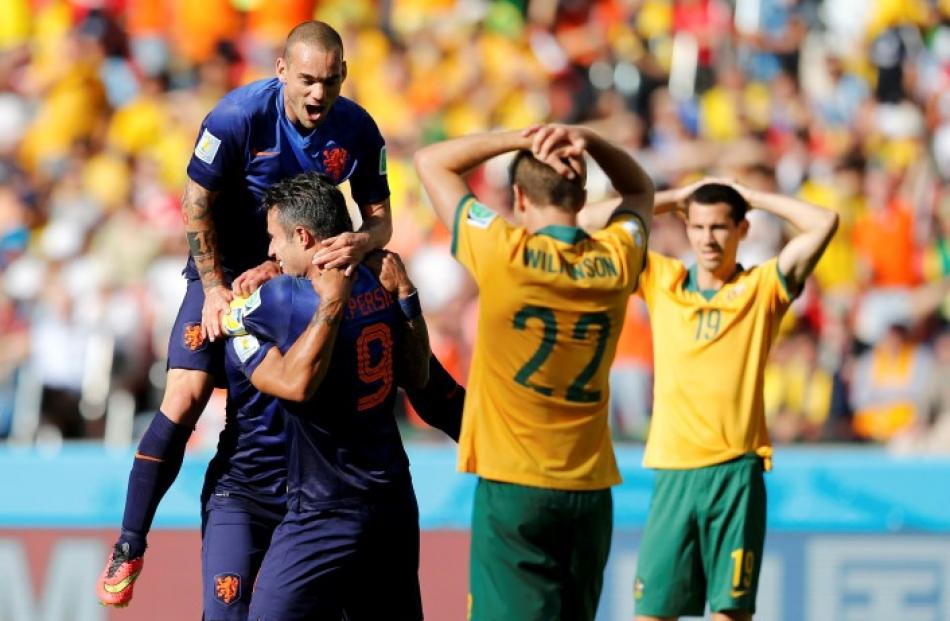 Australian players show their disappointment as Robin van Persie (9) of the Netherlands...
