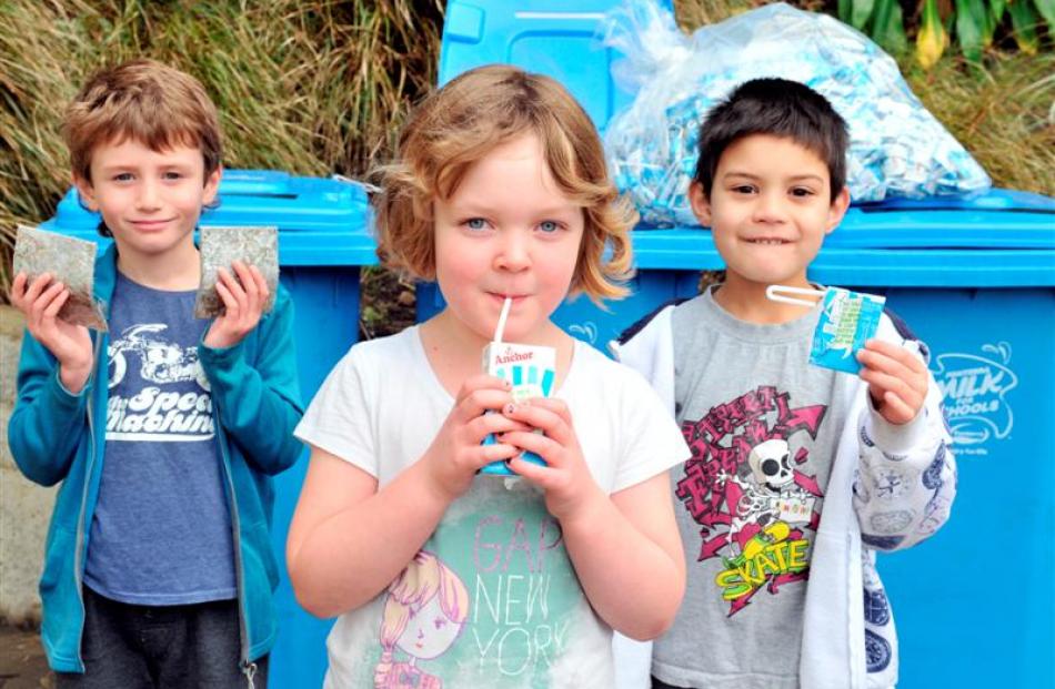 Babet Doherty (6) (centre) drinks milk at George Street Normal School yesterday while fellow...