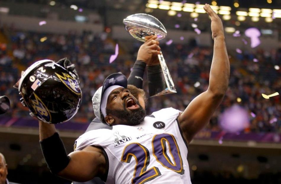 Baltimore Ravens free safety Ed Reed (20) celebrates next to the Vince Lombardi Trophy after his...