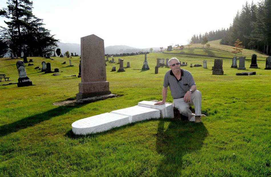 Bill Price surveys the damage to his late mother’s headstone at West Taieri Cemetery. Photos by...