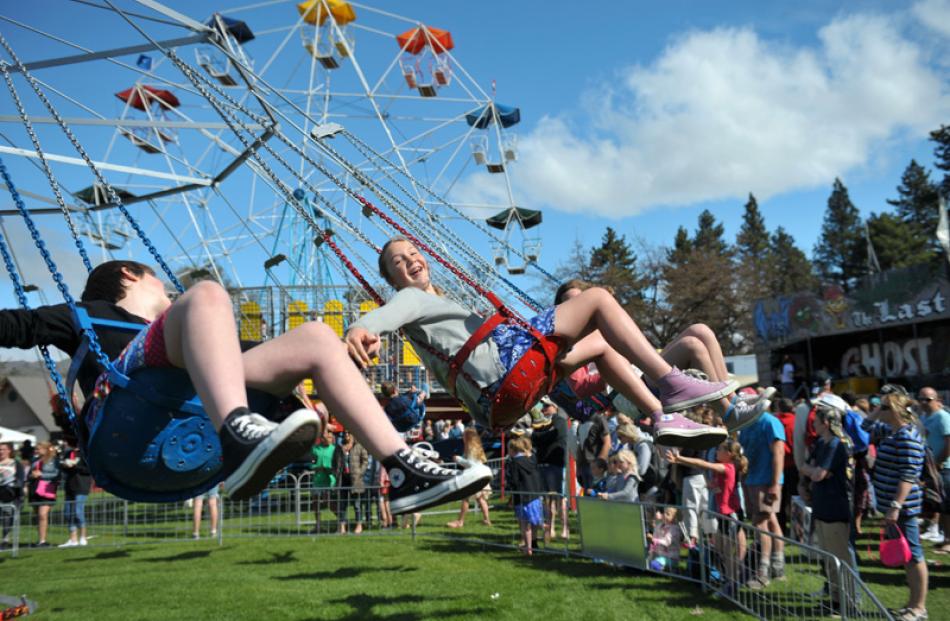 Olivia Kotkamp holds Hannah Anderson's hand while riding on the fast and furious swing carousel.