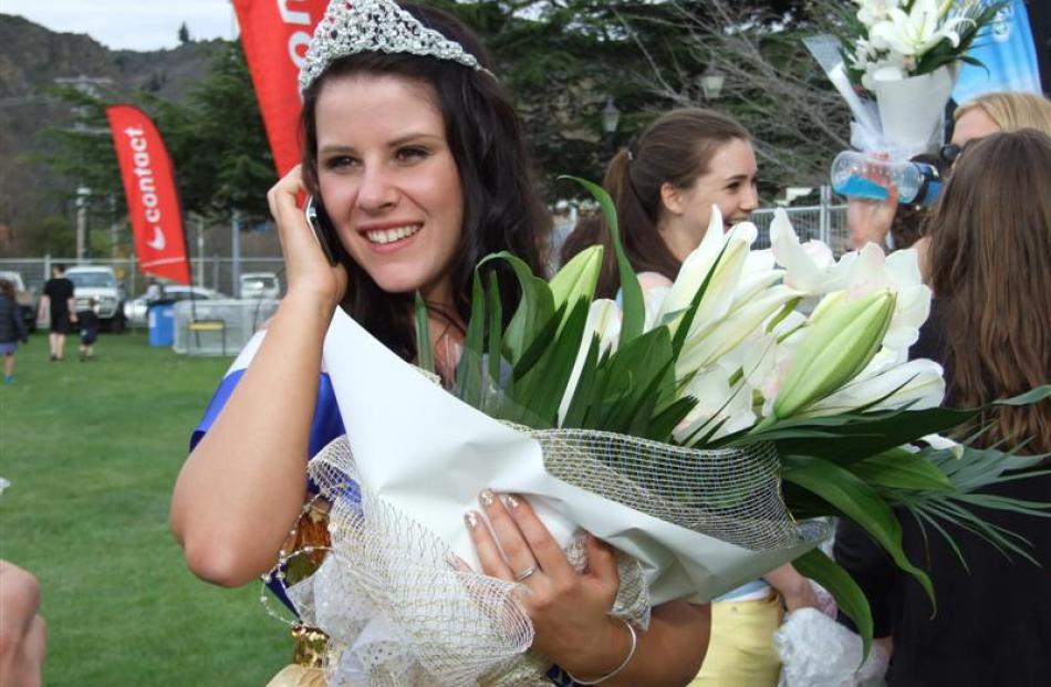 Blossom Festival Queen Ellie Trask (18) takes a congratulatory call after the crowning ceremony....