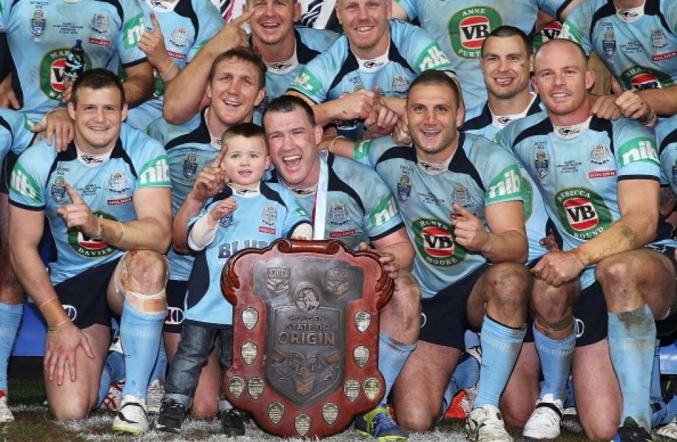 Blues players pose with the trophy after game three of the State of Origin series. (Photo by Mark...