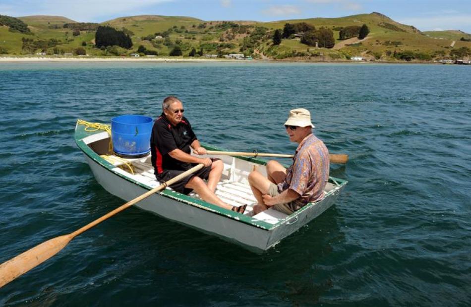 Bob Mitchell (left) and Des Gray, both of Otakou, paddle on after setting a net for moki off...