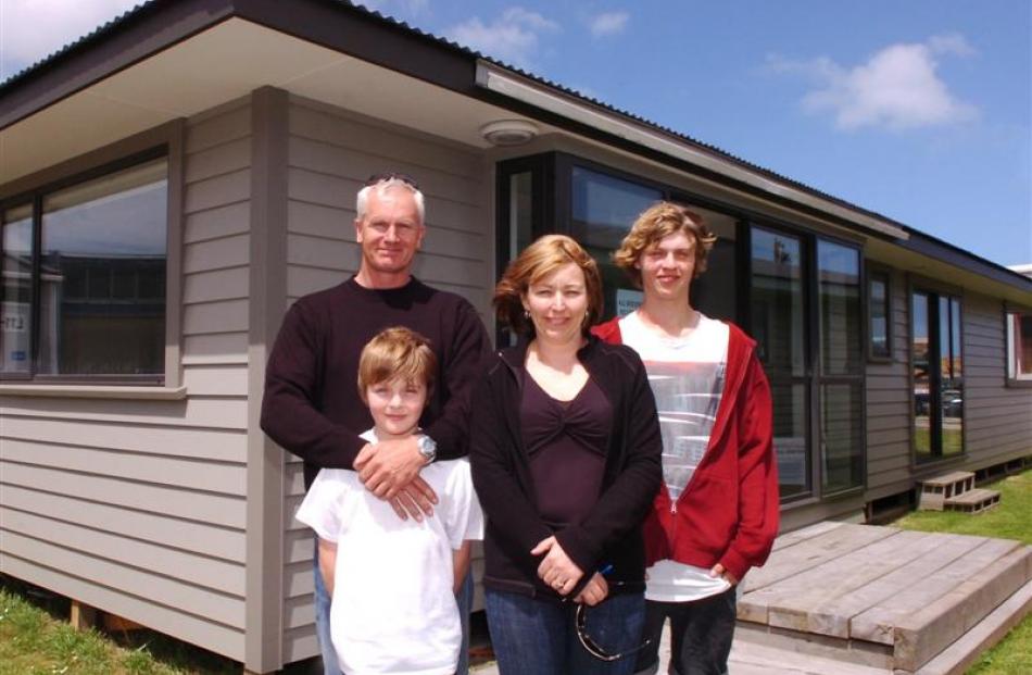 Bruce and Maxine Murdoch and their two children, Benji (10) and Thomas (16), stand in front of...