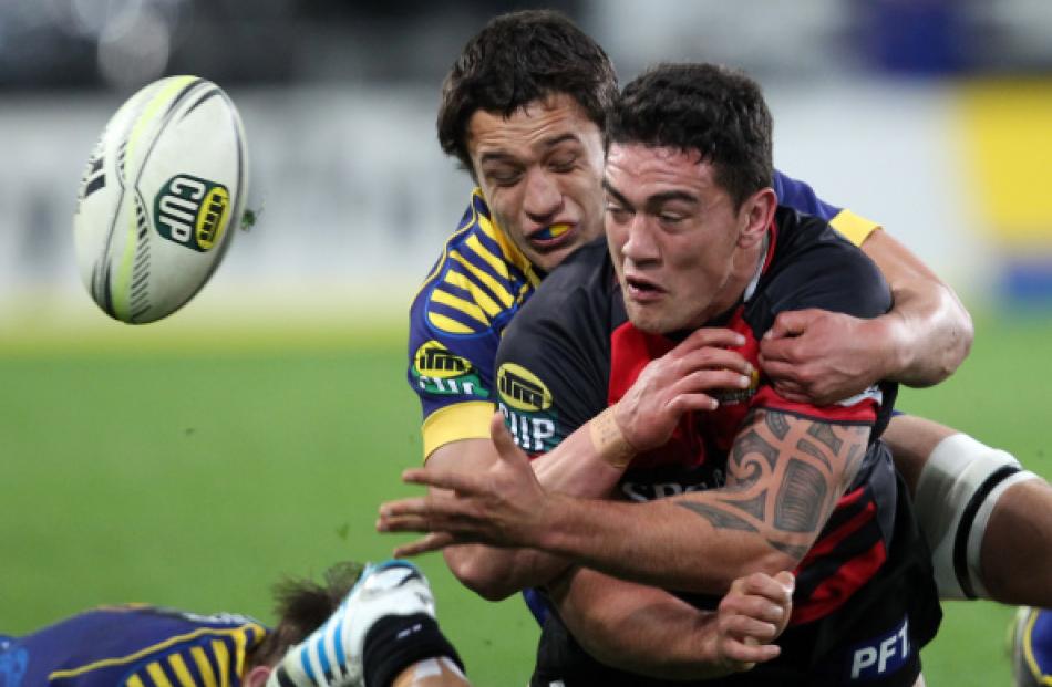 Canterbury's Codie Taylor gets a pass away in the tackle of Otago's Lee Allan. (Photo by Rob...