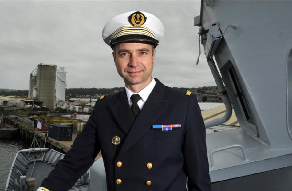 Captain Frederic Daumas stands on the wing of the bridge of the French naval vessel FNS Prairial...