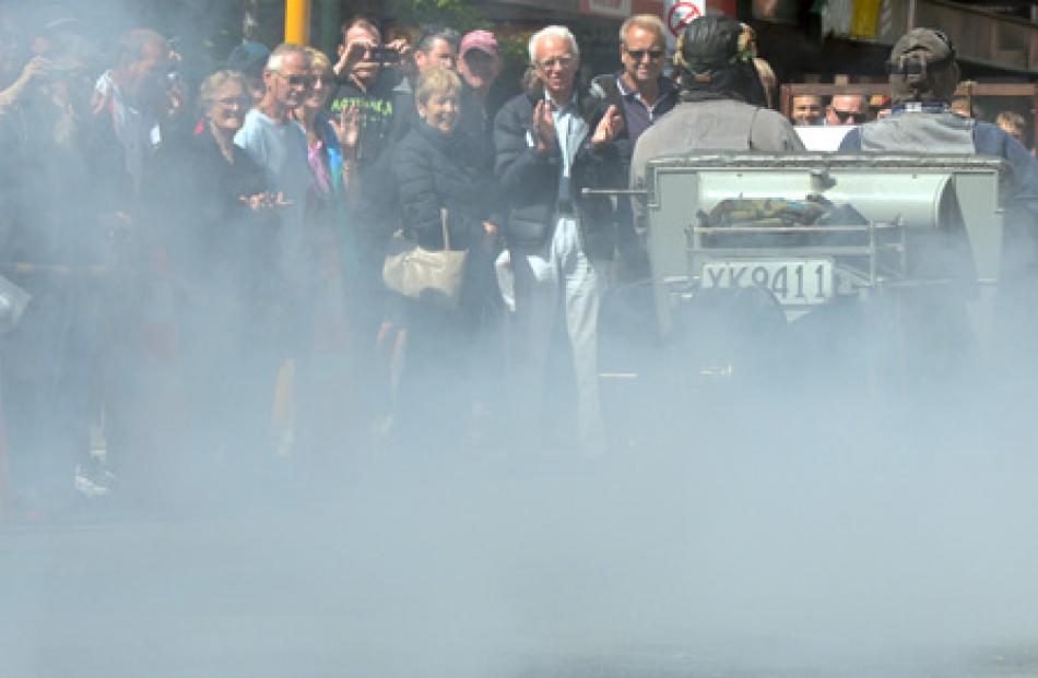 A 1911 AC Sociable sends smoke billowing into the Octagon crowd.