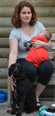 Carol  sits outside a cabin at Dunedin Holiday Park with her 8-week-old son William and her dog...