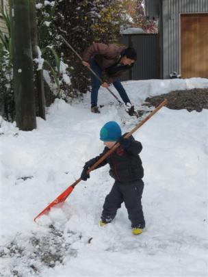 Carter Sanson (2) helps his mother, Ros, clear snow from their driveway in Arrowtown yesterday....