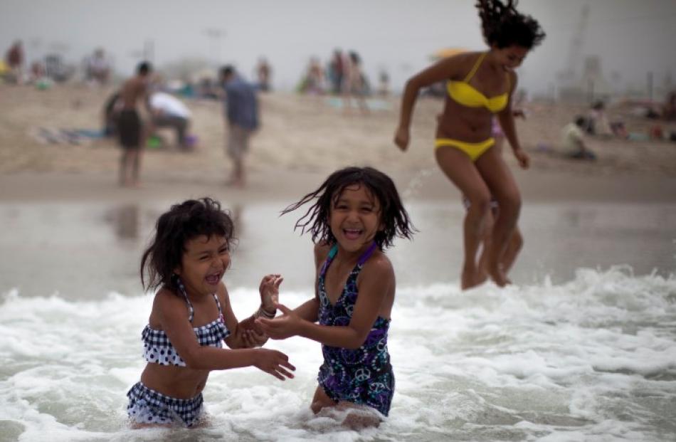 Celeste Hidalgo (7, R) and Alana Griego (5) cool off in the Pacific Ocean in Santa Monica,...
