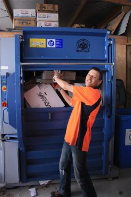 Central Otago WasteBusters employee Franky Harris loads cardboard into a new baling machine that...