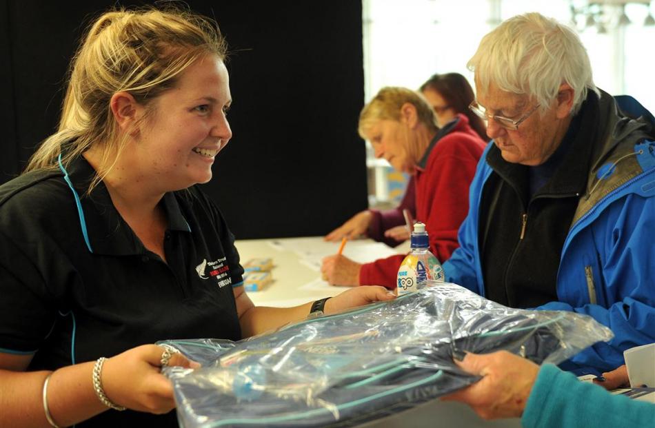 Charlotte Meiklejohn (left) gives out Masters Games uniforms to volunteers including Shirley...