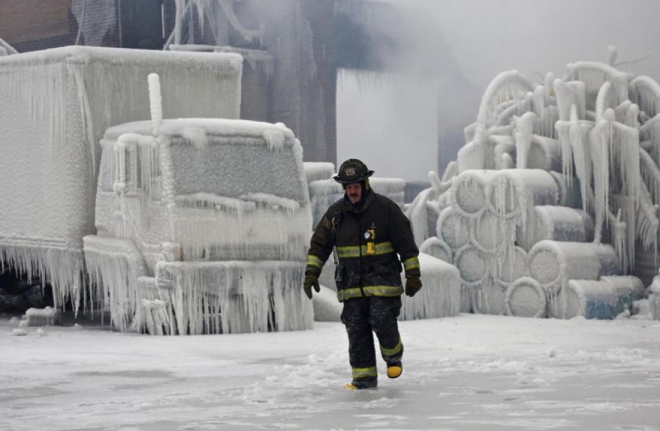 Chicago Fire Department Lieutenant Charley De Jesus walks around an ice-covered warehouse that...