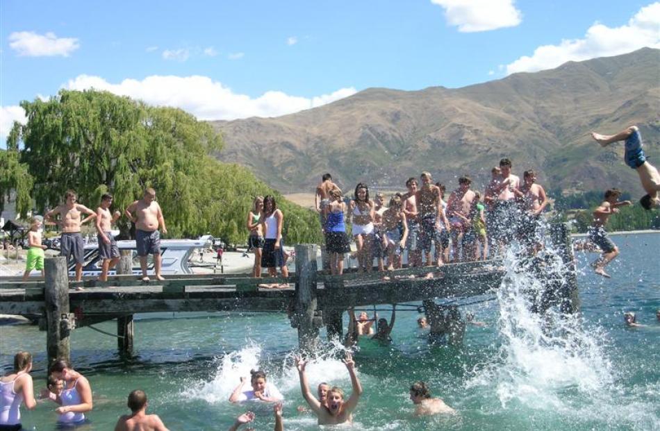 Children line up to jump off the jetty as the temperature soars above 30degC in Wanaka. Photos by...