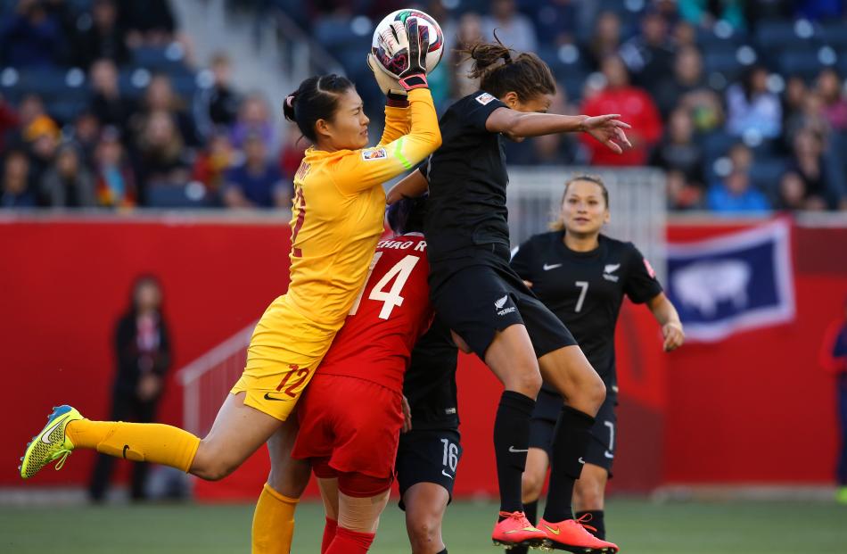 China goalkeeper Wang Fei makes a save against New Zealand forward Amber Hearn during the match...