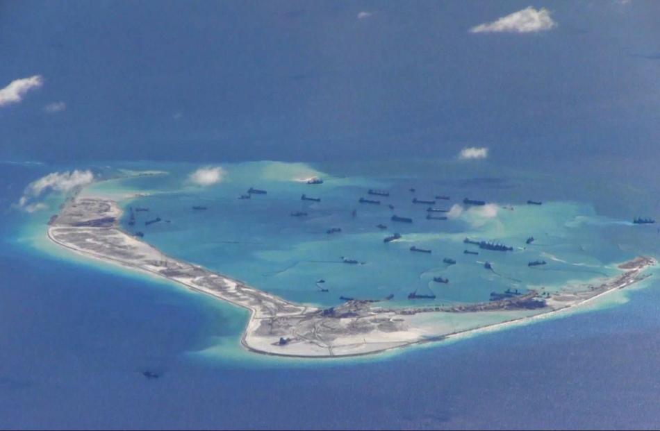 Chinese dredging vessels in waters around Mischief Reef in the disputed Spratly Islands. Photo by...