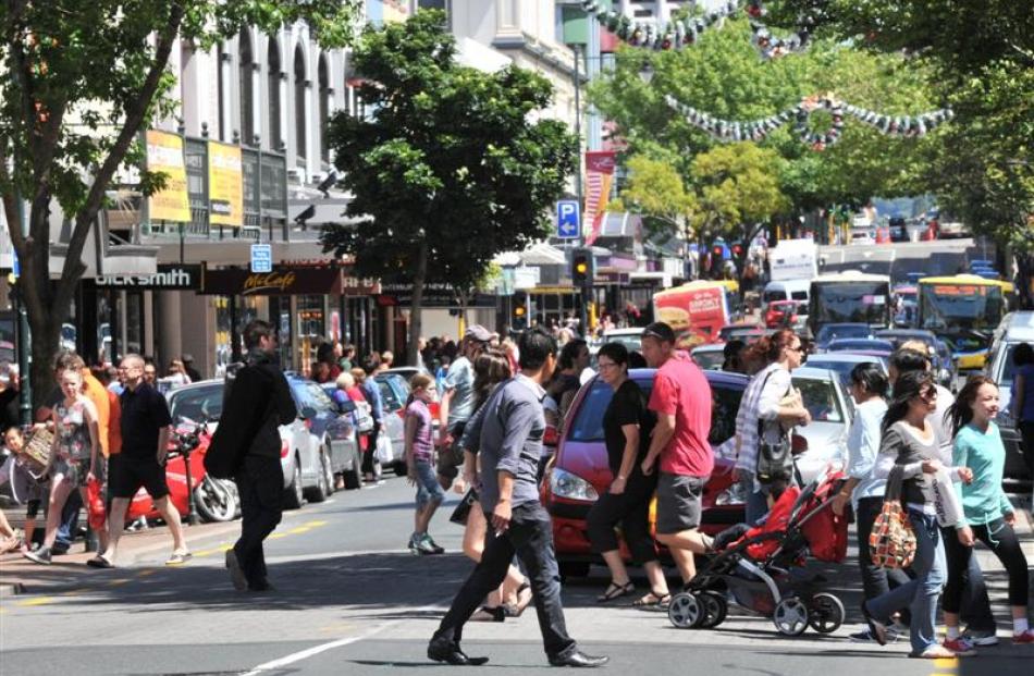 Christmas shoppers walk across a busy George St on Saturday afternoon.