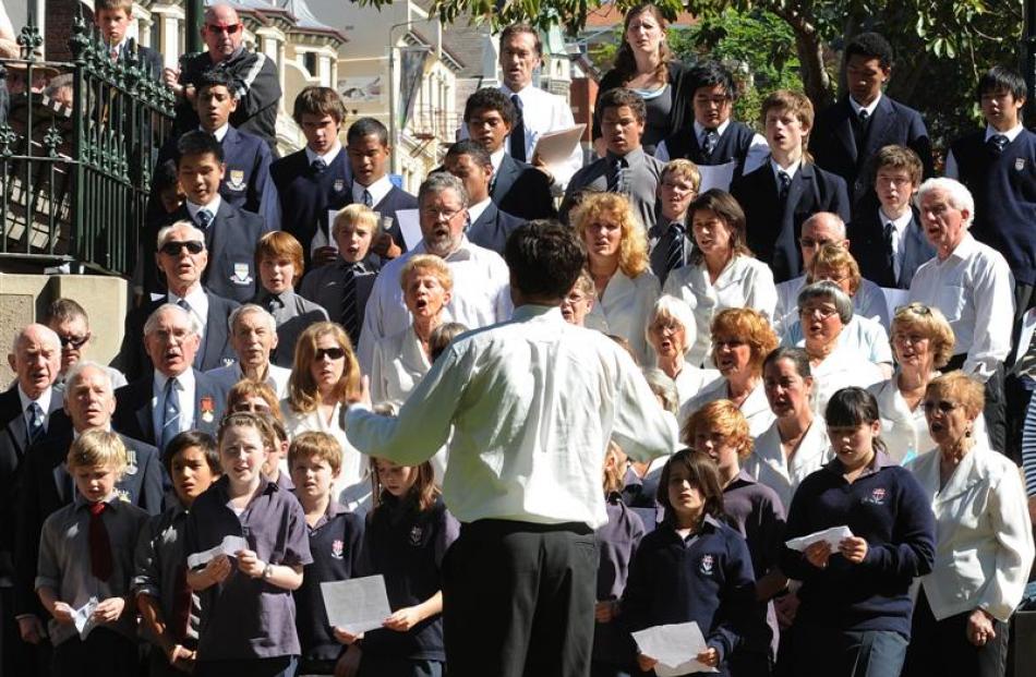 City of Dunedin Choir musical director David Burchell conducts the national anthem in the Octagon...