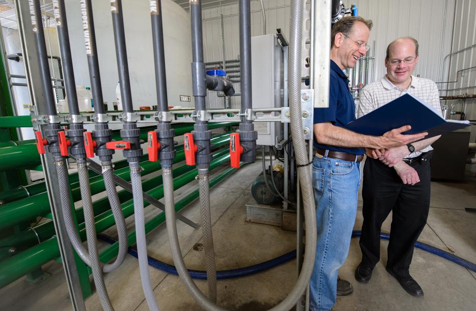 Cleaning effluent . . . Discussing their system, which converts manure into clean water, on a...