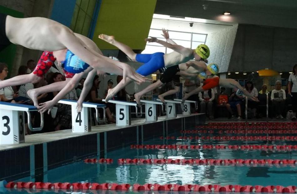 Competitors in the boys 11-12 years 50m freestyle start their race at the Earlybird swim meet at...