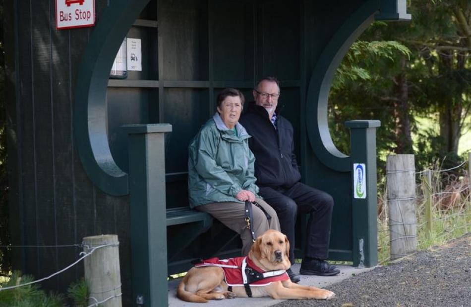 Concord residents Lynn and Kevin Keogh, and her  3-year-old guide dog,  Matsi, sit at a bus...