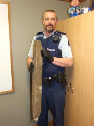 Constable Terry Erceg holds the piece of metal which came off a truck's trailer and hit a car on...