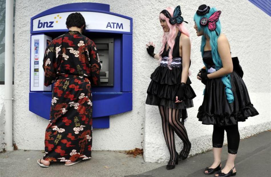 Cosplayers (from left) Kyotaek Son as "Kimihiro Watanuki",  Jessica Ung as "Megurine Luka" and...