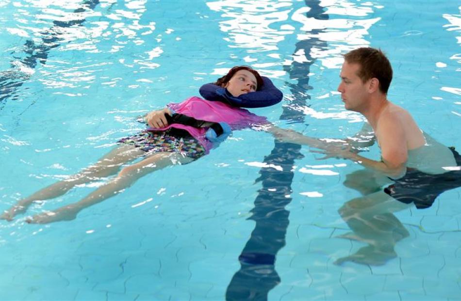 Courtney Donald swims in the physio pool with the help of physiotherapist Mark Shirley. Photo by...