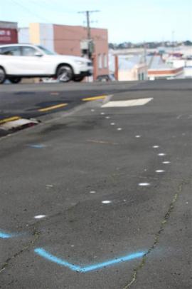 Crash investigators' spray paint markings show the trajectory and final resting spot of the car...