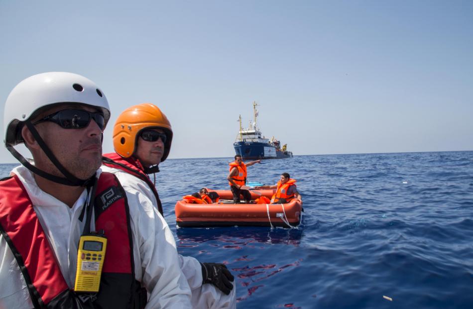 Crew from the Dignity 1 search and rescue vessel scan the sea for survivors. Photo: Reuters