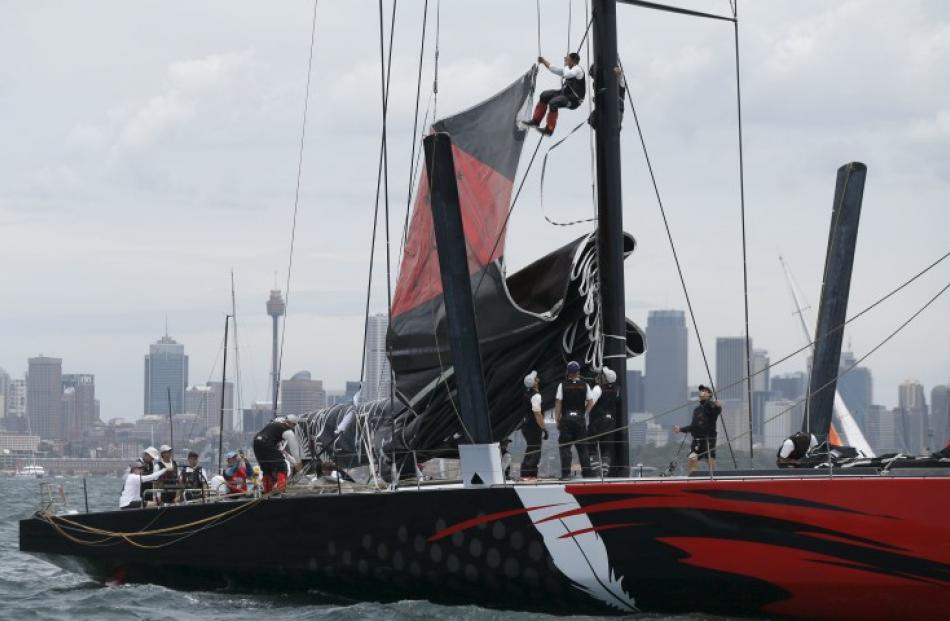Crew members work Comanche's main mast during preparations for the start of the race on Boxing...