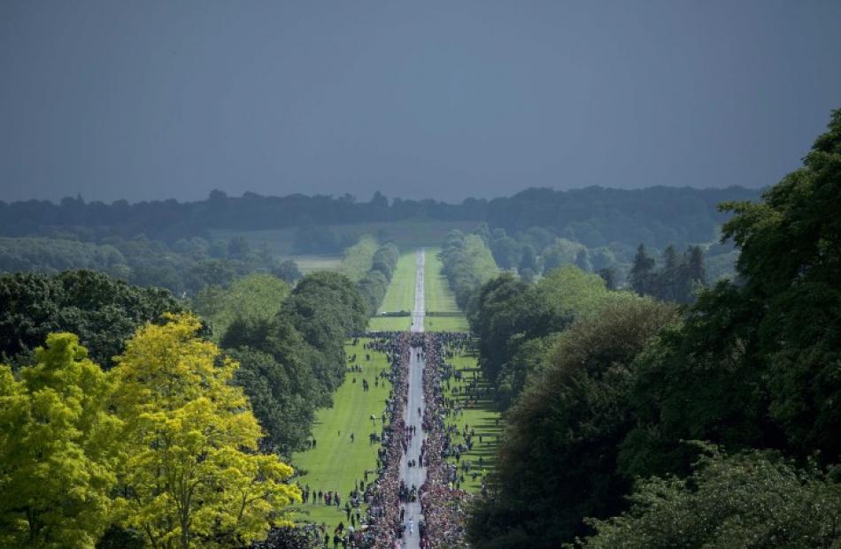 Crowds gather to watch as the Olympic Flame arrives at Windsor Castle, west of London yesterday....