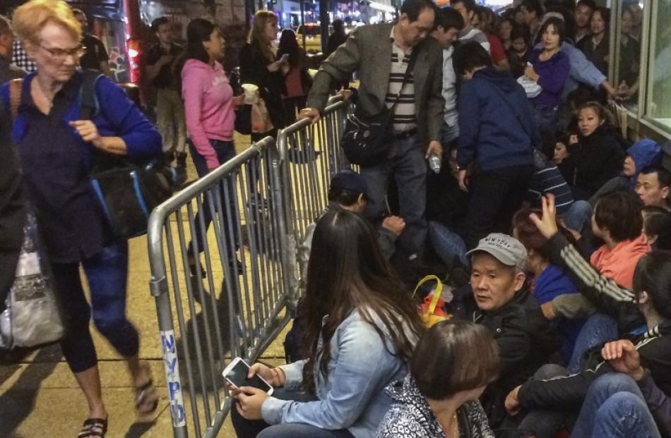 Customers wait in line to buy the newly released iPhone 6 and iPhone 6 Plus, on the first day of...