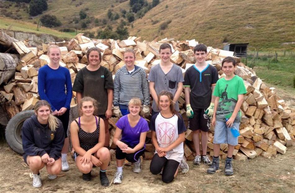 Cutting firewood to raise funds for their African trip are Taieri College pupils (back, from left...