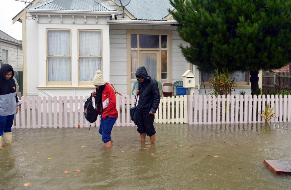 Darcel, Chantelle and Felix Pese evacuate their Nicholson St house about noon as floodwaters rise...