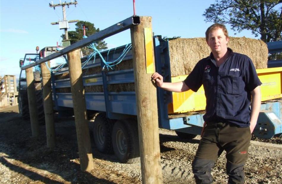 Dave McCabe with the system he has designed to easily pull strings from bales on feed-out wagons....