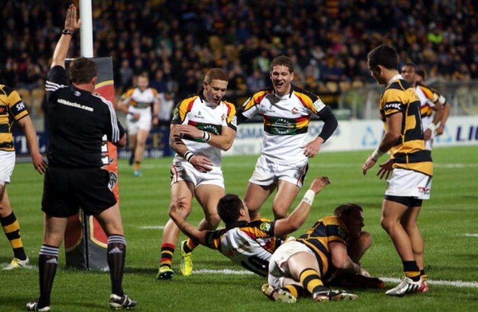 Declan O'Donnell (left) and Tawera Kerr-Barlow of Waikato congratulate Sam Christie on his try...