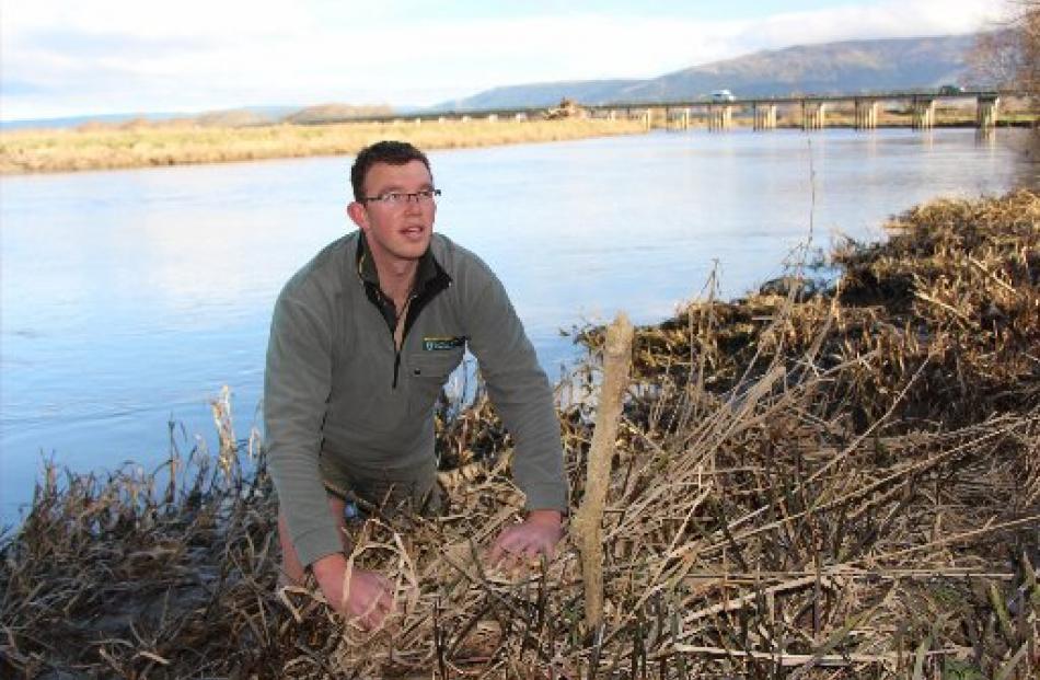 Department of Conservation freshwater ranger Ciaran Campbell, of Dunedin, examines the fast...