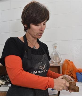 Di Tocker works on a wax model that will form the  shape of one of her cast-glass works. Photos...