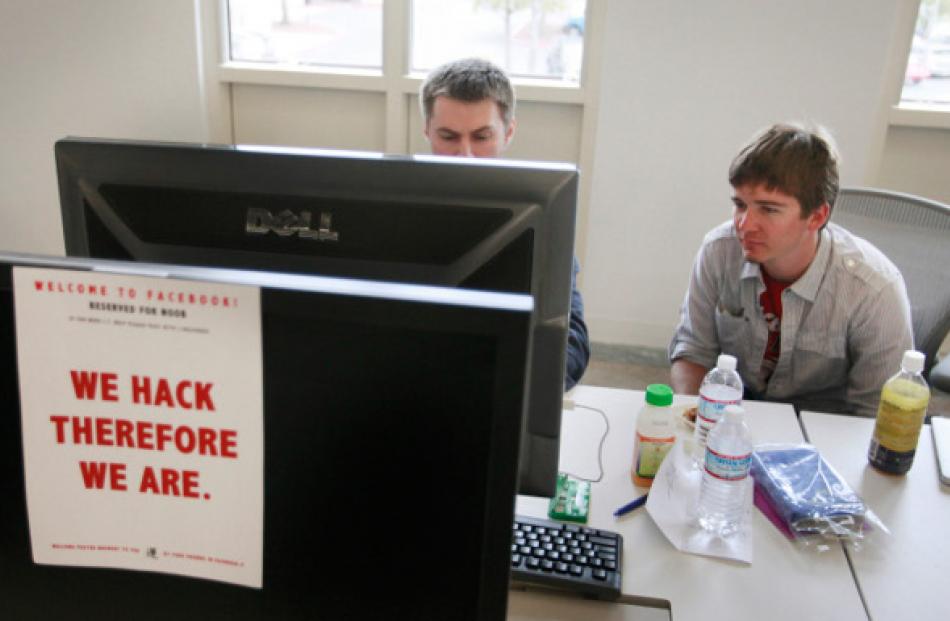 Dimitry Soshnikov (left) writes code as Ryan Patterson helps him during a boot camp at Facebook's...